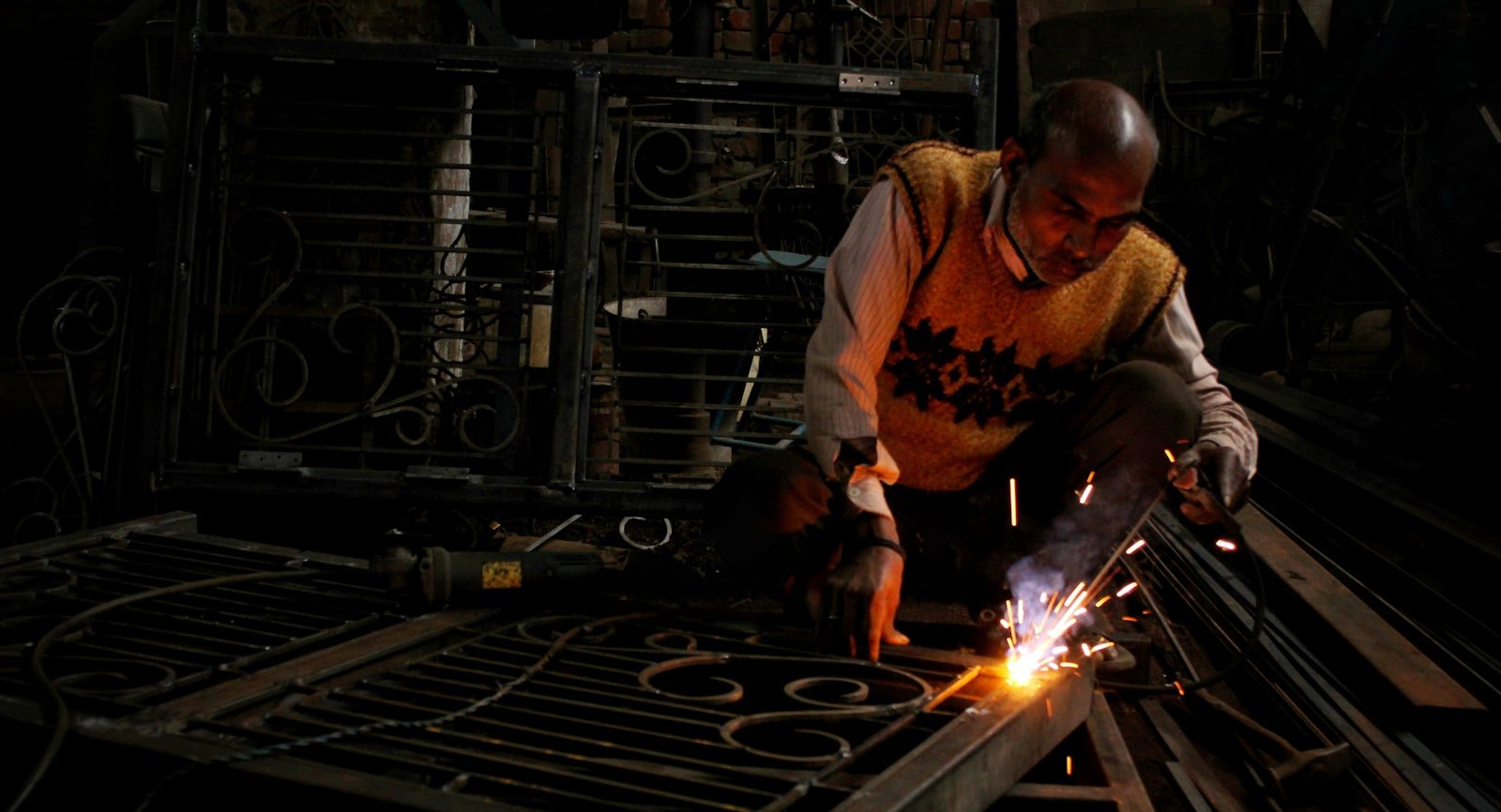Atelier de fabrication d'un portail en fer, étincelles de soudure